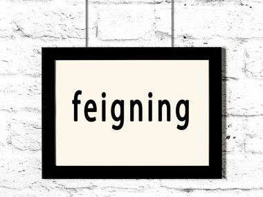 Siyah ahşap çerçeve ve beyaz tuğla duvarda sahte yazılar asılı. 