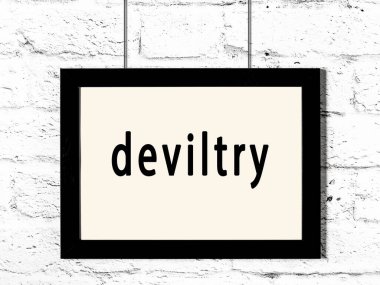 Siyah ahşap çerçeve, beyaz tuğla duvarda yazıtlar asılı. 