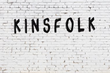 Yazılı beyaz tuğla duvar. Siyah boyayla yazılmış akrabalar.
