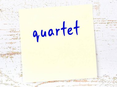 Dörtlüyü hatırlatma kavramı. Tahta duvarda üzerinde yazı olan sarı yapışkan kağıt.