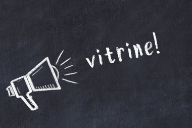 Hoparlörün tebeşir çizimi ve siyah masanın üzerine el yazısıyla yazılmış vitrin.