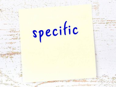 Belirli bir şeyi hatırlatma kavramı. Tahta duvarda üzerinde yazı olan sarı yapışkan kağıt.