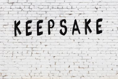 Üzerinde siyah boya olan beyaz tuğla bir duvar.