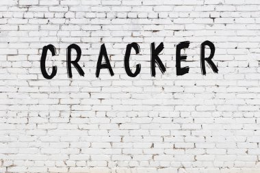 Beyaz tuğla duvara siyah boya ile yazılmış bir kraker..