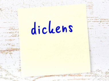 Dickens 'ı hatırlatma kavramı. Tahta duvarda üzerinde yazı olan sarı yapışkan kağıt.