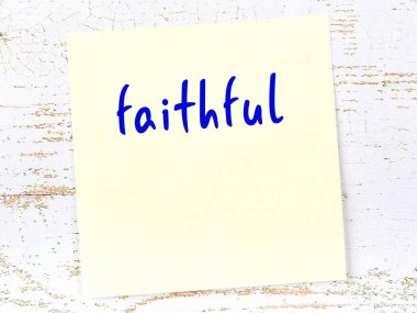 Sarı yapışkan not ahşap duvarda el yazısıyla yazılmış sadık bir yazı.