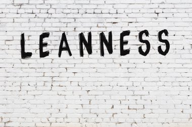 Üzerinde siyah boya bulunan beyaz tuğla bir duvar.