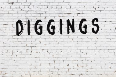 Siyah boyayla el yazısıyla kazılmış beyaz tuğla duvar.