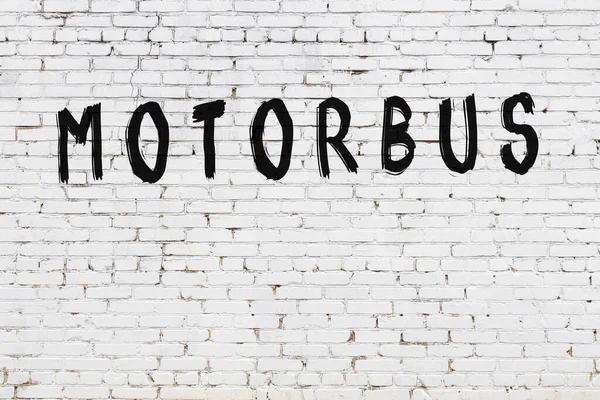 白いレンガの壁に黒塗料で書かれた碑文のオートバイ — ストック写真