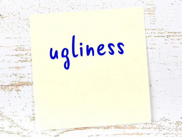 Tahta duvardaki sarı yapışkan notta el yazısı çirkinlik var.