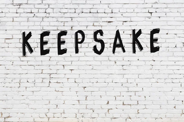 Üzerinde siyah boya olan beyaz tuğla bir duvar.