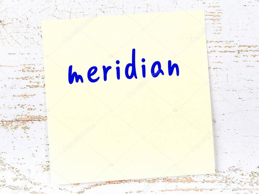 Concept of reminder about meridian. Yellow sticky sheet of paper on wooden wall with inscription
