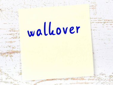 Tahta duvarda el yazısıyla yazılmış sarı yapışkan bir not var.