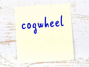 Çarkla ilgili hatırlatma kavramı. Tahta duvarda üzerinde yazı olan sarı yapışkan kağıt.