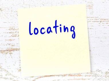 Tahta duvarda el yazısıyla yazılmış sarı yapışkan bir not var.