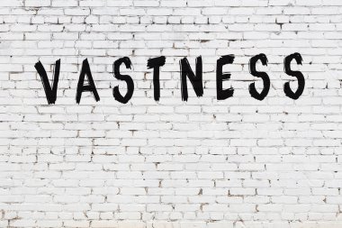 Beyaz tuğla duvara siyah boya ile yazılmış engin bir yazı..