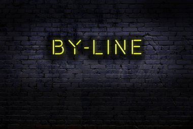 Üzerinde tuğla duvara karşı yazı olan neon tabela. Gece görünümü