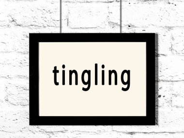 Üzerinde yazı olan siyah ahşap çerçeve beyaz tuğla duvarda asılı. 