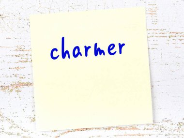 Charmer 'ı hatırlatma kavramı. Tahta duvarda üzerinde yazı olan sarı yapışkan kağıt.