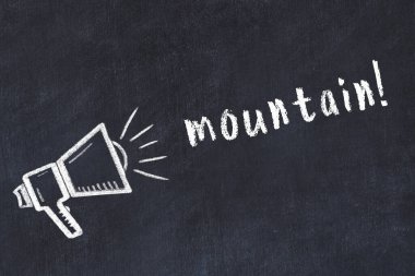 Hoparlörün tebeşir çizimi ve siyah masanın üzerine el yazısıyla yazılmış bir dağ.