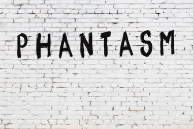 Üzerinde siyah boya olan beyaz tuğlalı bir duvar.