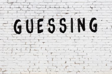 Üzerinde yazı olan beyaz tuğla duvar. Siyah boyayla el yazısı olduğunu tahmin ediyorum.