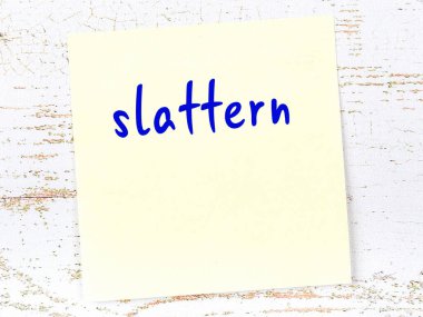 Sürtük hakkında hatırlatma kavramı. Tahta duvarda üzerinde yazı olan sarı yapışkan kağıt.