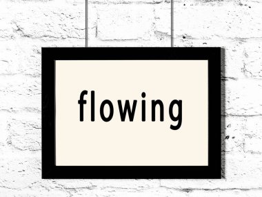 Beyaz tuğla duvarda asılı duran siyah ahşap çerçeve. 