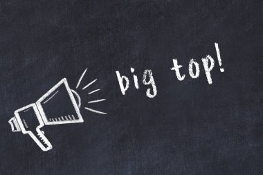 Hoparlörün tebeşir çizimi ve siyah masanın üzerine el yazısıyla yazılmış büyük bir yazı.