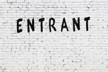 Beyaz tuğla duvara siyah boya ile yazılmış bir yazı..