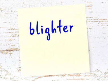 O hergeleyi hatırlatma anlayışı. Tahta duvarda üzerinde yazı olan sarı yapışkan kağıt.