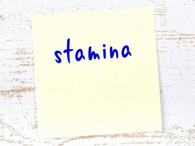 Dayanıklılığı hatırlatan kavram. Tahta duvarda üzerinde yazı olan sarı yapışkan kağıt.