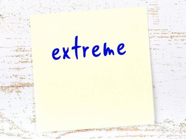 Tahta duvardaki sarı yapışkan notta elle yazılmış aşırı yazılar var.