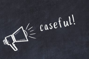 Hoparlörün tebeşir çizimi ve siyah masanın üzerine el yazısıyla yazılmış bir yazı.