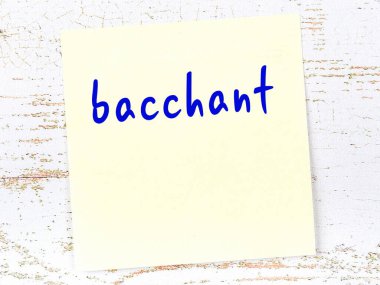 Tahta duvarda el yazısıyla yazılmış sarı yapışkan bir not var.