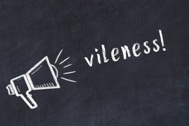 Hoparlörün tebeşir çizimi ve siyah masaya el yazısıyla yazılmış iğrençlik.