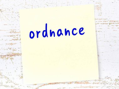 Tahta duvardaki sarı yapışkan notta el yazısıyla yazılmış mühimmat var.