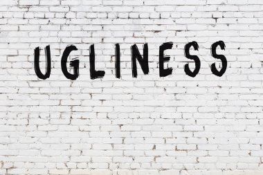 Üzerinde yazı olan beyaz tuğla duvar. El yazısıyla siyah boya.