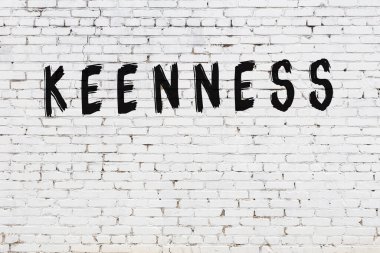 Üzerinde siyah boya bulunan beyaz tuğla bir duvar.