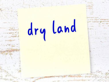 Kuru toprakları hatırlatma kavramı. Tahta duvarda üzerinde yazı olan sarı yapışkan kağıt.