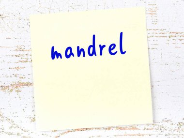 Tahta duvarda el yazısıyla yazılmış sarı yapışkan bir not var.