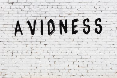 Üzerinde siyah boya bulunan beyaz tuğla bir duvar.