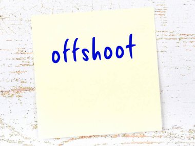 Tahta duvarda el yazısıyla yazılmış sarı yapışkan bir not var.