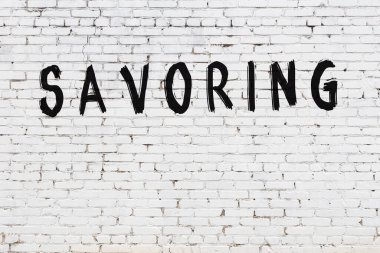 Yazı zevki beyaz duvarda siyah boya ile yazılmış..