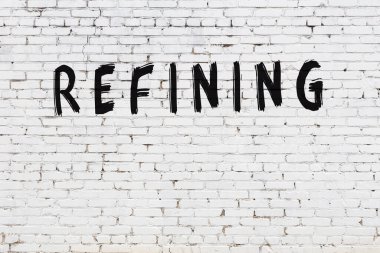 Beyaz tuğla duvara siyah boya ile yazılmış yazı rafinerisi.