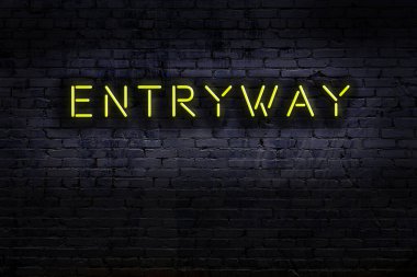 Üzerinde tuğla duvarın girişinin yazılı olduğu neon tabela. Gece görünümü