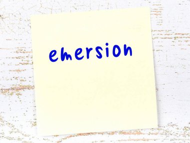 Emersion 'ı hatırlatma kavramı. Tahta duvarda üzerinde yazı olan sarı yapışkan kağıt.