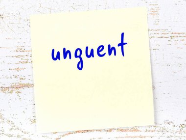 Merhem hakkında hatırlatma kavramı. Tahta duvarda üzerinde yazı olan sarı yapışkan kağıt.