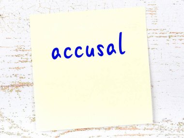 Tahta duvardaki sarı yapışkan notta elle yazılmış itham yazısı var.