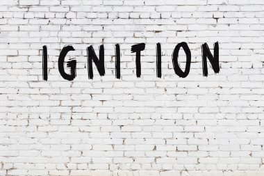 Yazı, beyaz tuğla duvara siyah boya ile yazılmış..